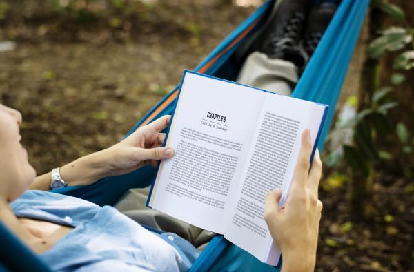 Person reading book in a hammock