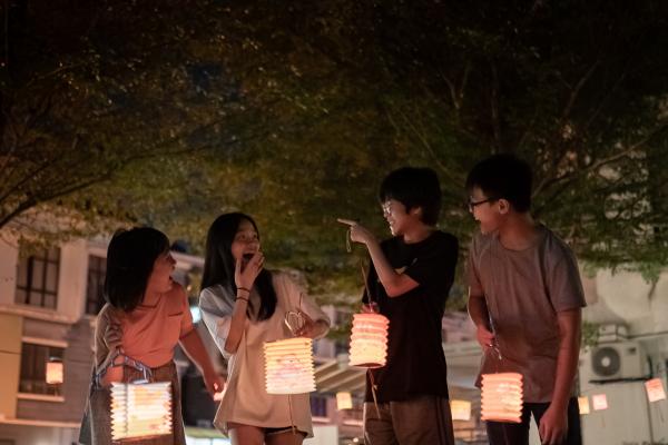 People holding paper lanterns.