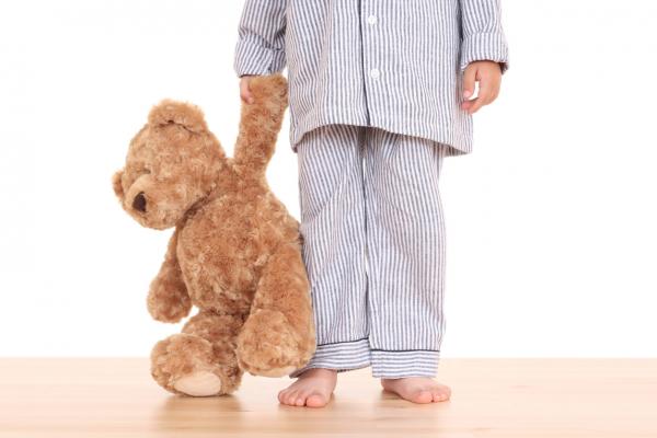 Child in pajamas with a teddy bear
